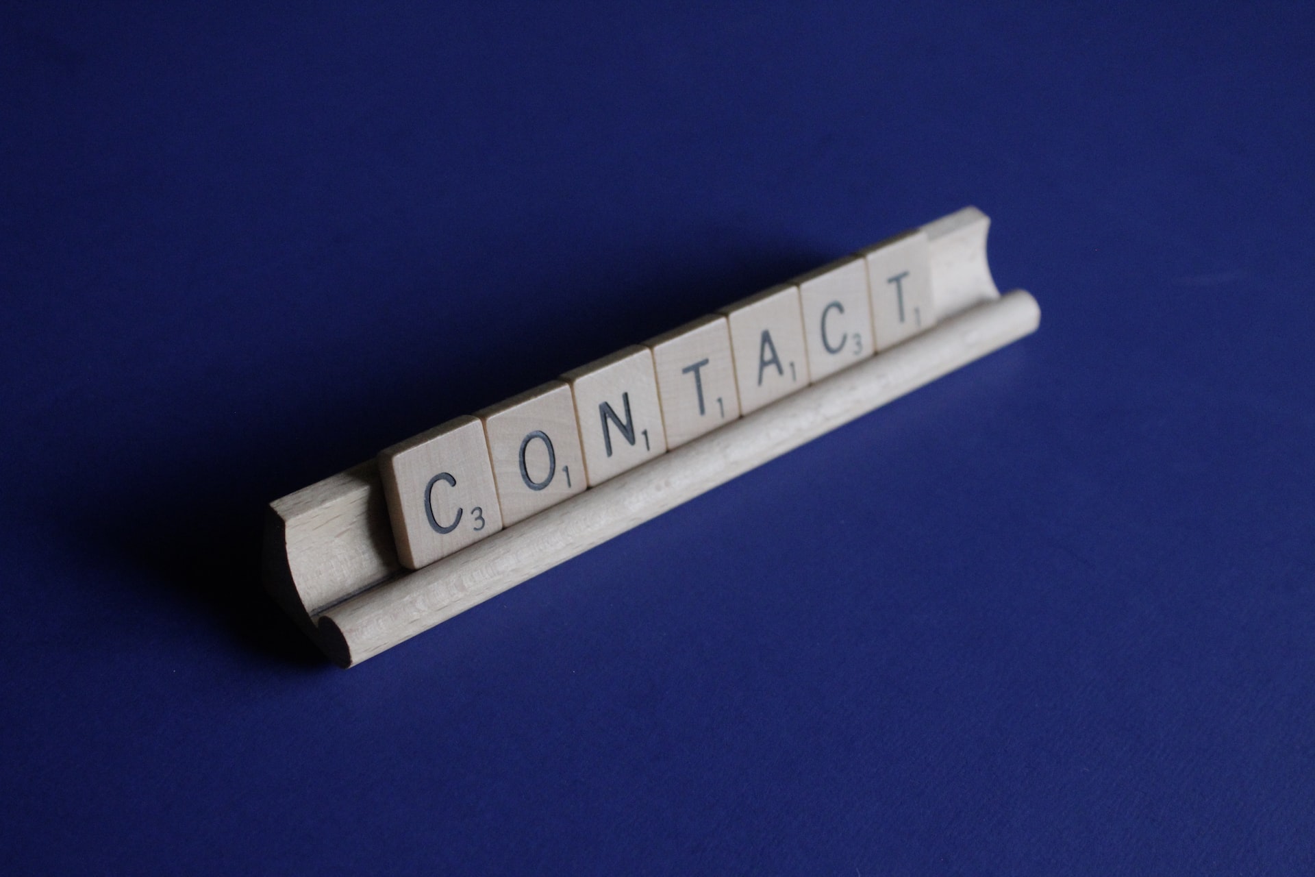 The word Contact made of wooden Scrabble letters