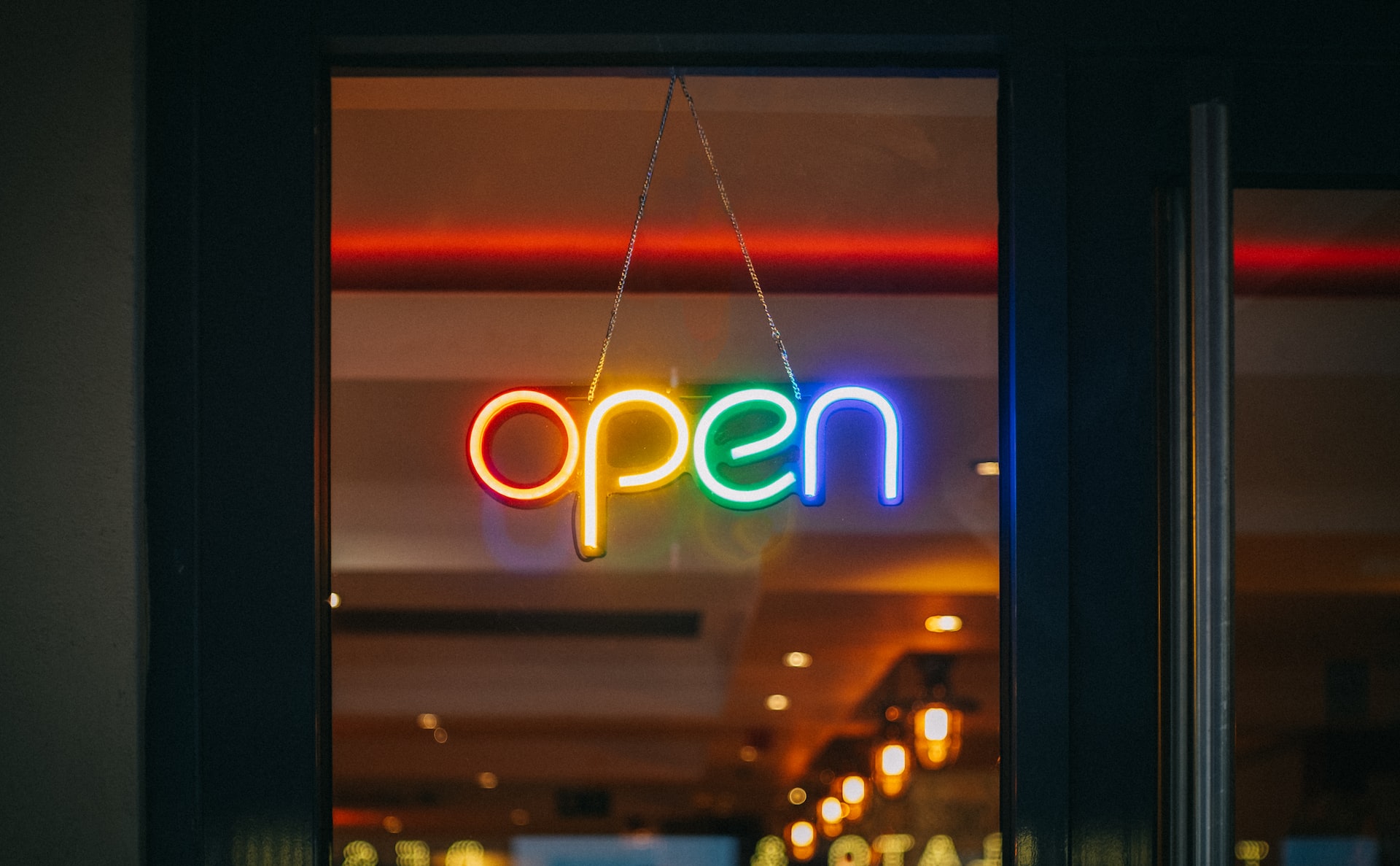 An Open sign in a window, made of rainbow neon lights